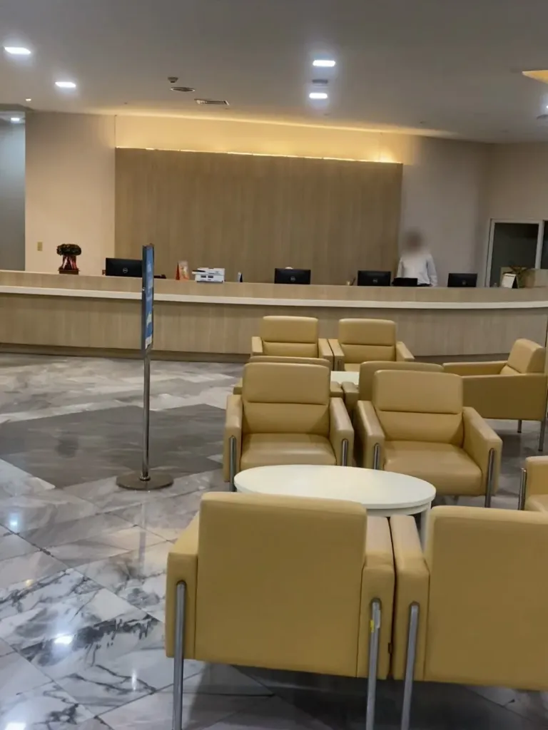ردهة الاستقبال الرئيسية في مستشفى بياويت بمكتب استقبال طويل ومقاعد انتظار جلدية